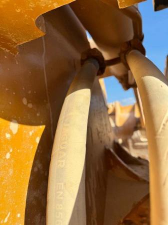 Hydraulic hoses and fittings inside yellow construction equipment
