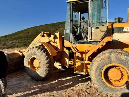 Hyundai wheel loader at a quarry with an operator in the cab