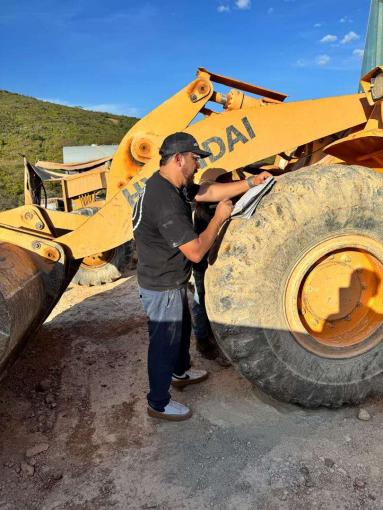 Technician recording information beside a wheel loader tyre